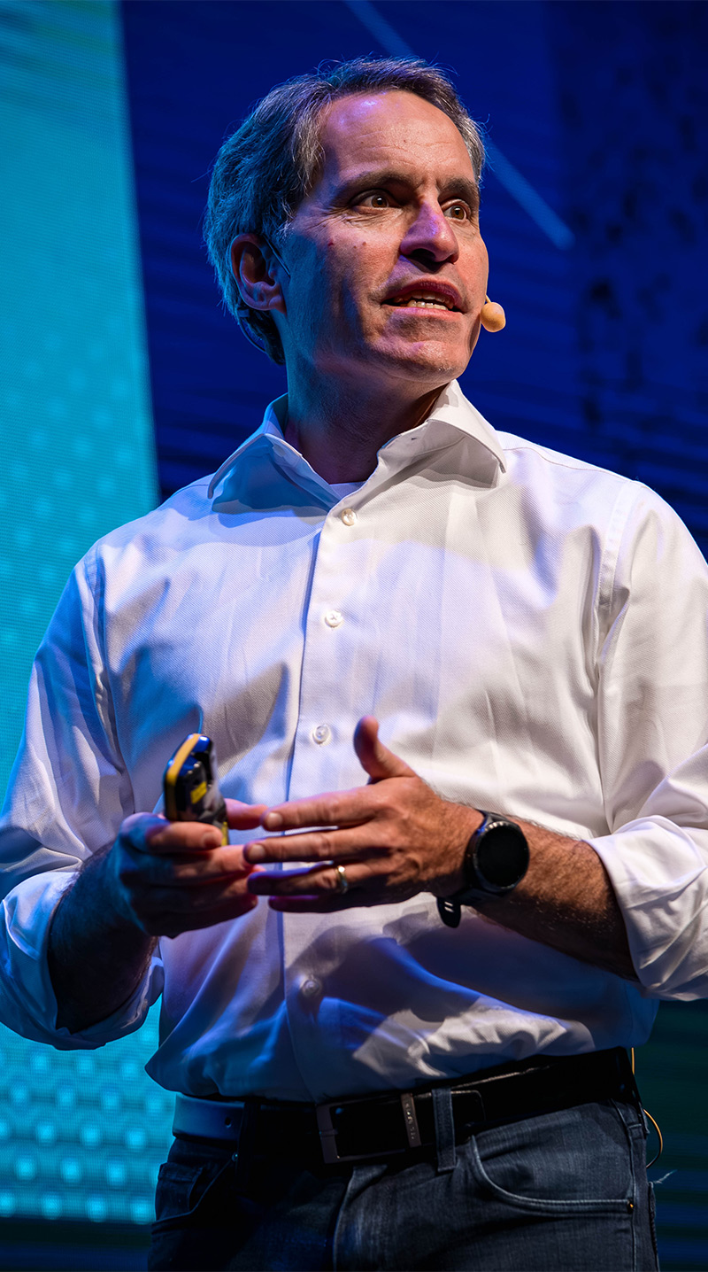 Jeff Teper addresses the audience while speaking on stage at a keynote