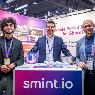 3 people smile for the camera while standing at their expo booth