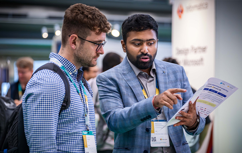 two people looking at a document at a demo booth in the expo hall