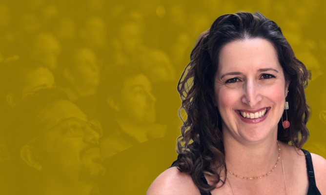 FabCon sponsor Sharon N. Berg smiles for the camera over a background of a sitting audience